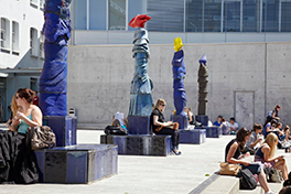 Aussenbereich vom Unitobler mit farbigen Keramikfiguren und Studierenden